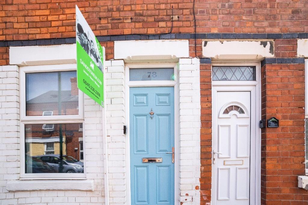 Charming brick terrace with colorful front door...