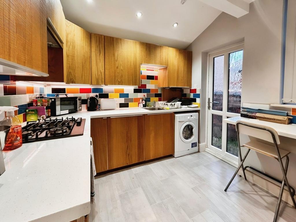 Bright modern kitchen with colorful tiled splas...