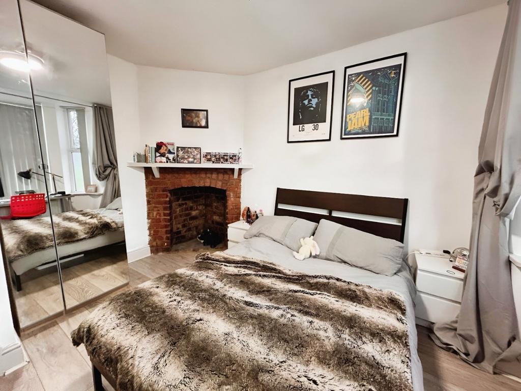 Cozy bedroom with fireplace and mirrored wardro...