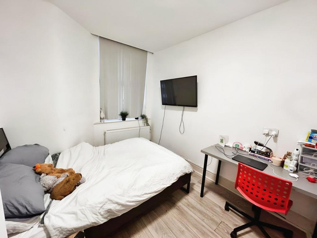 Bright bedroom with TV, desk and bed...