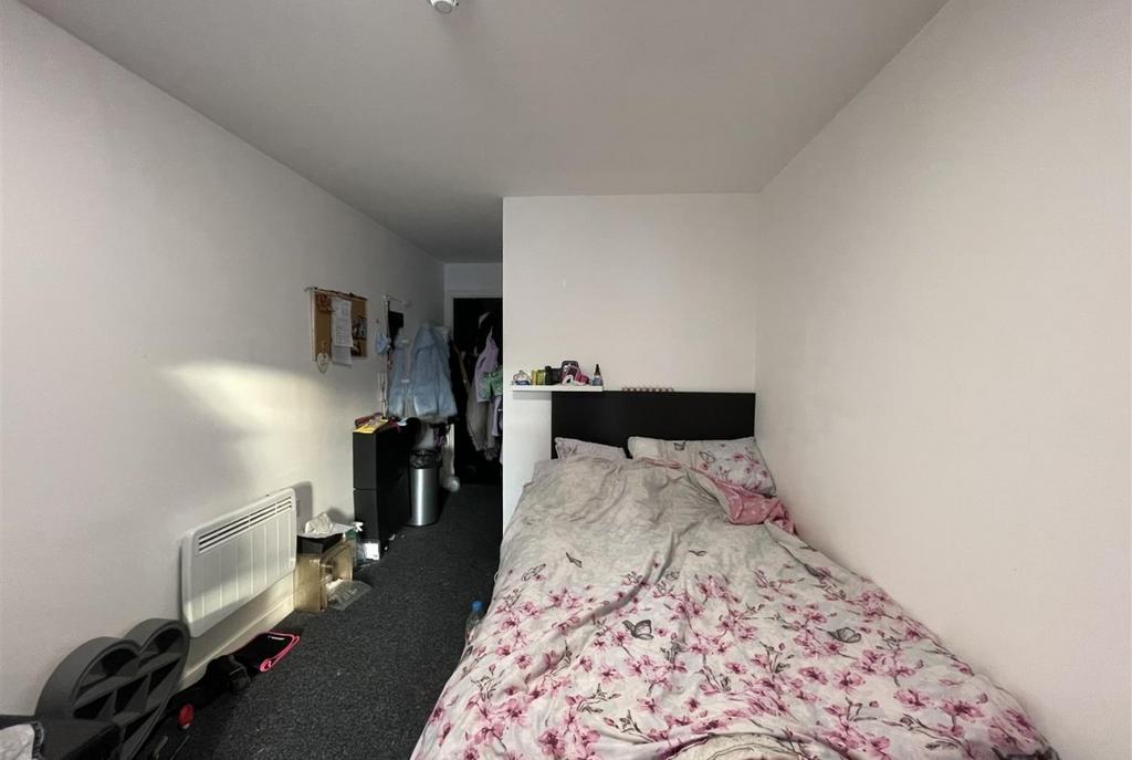 Compact, simply furnished bedroom with a comfor...