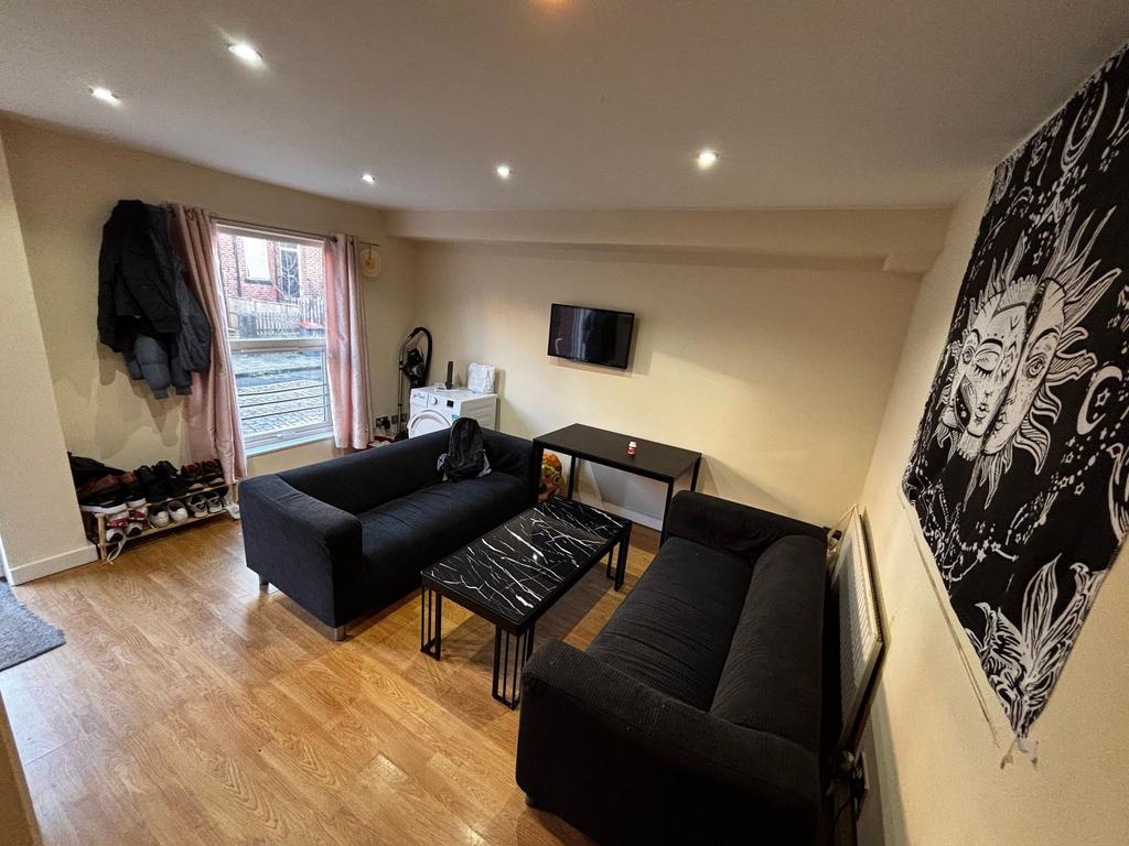 Bright, modern living room with two black sofas...
