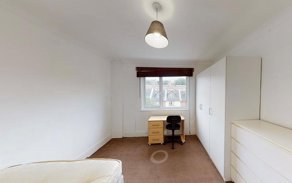 A neat and well-lit single bedroom with a windo...