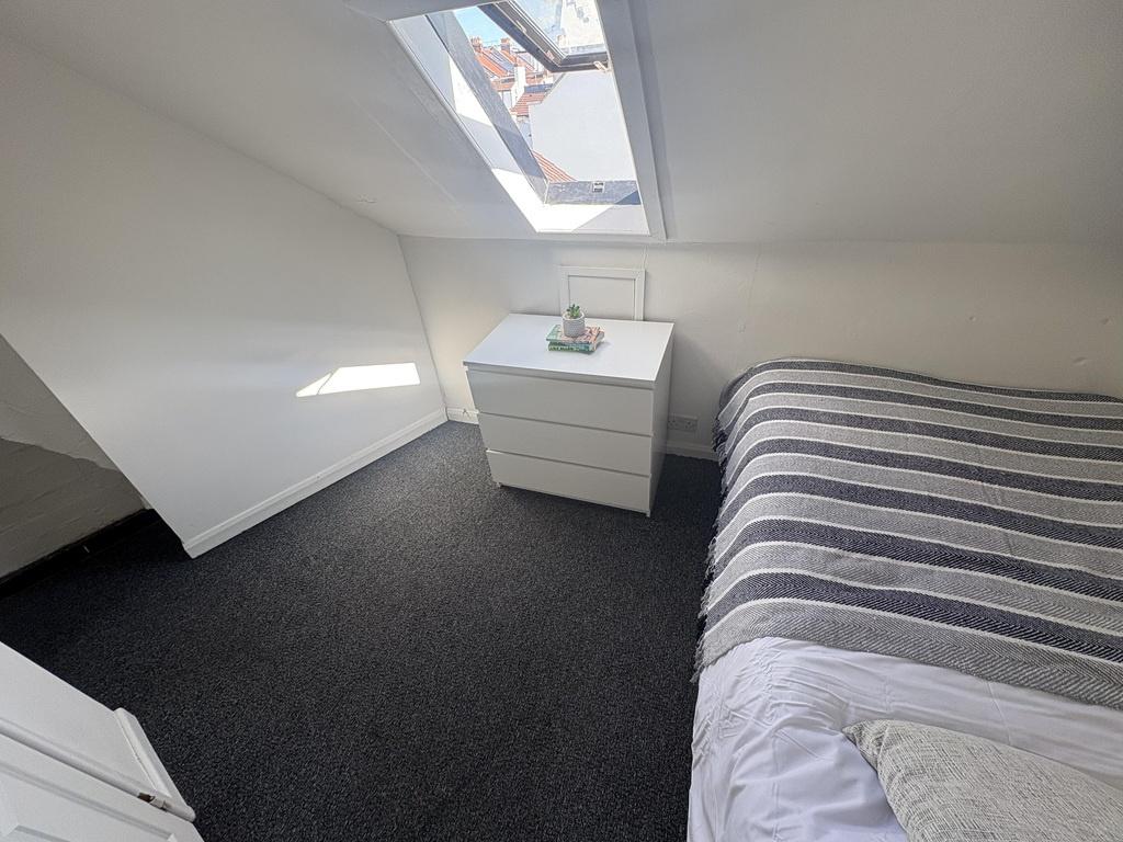 Compact attic bedroom with skylight and neat de...