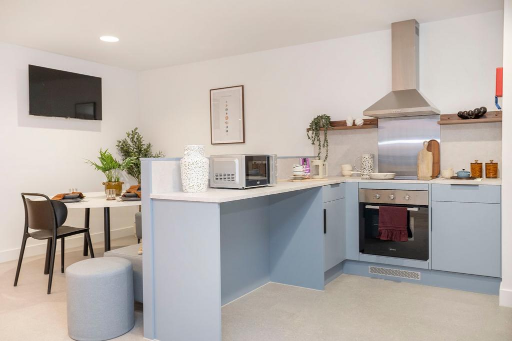 Bright modern kitchen with soft blue cabinetry,...