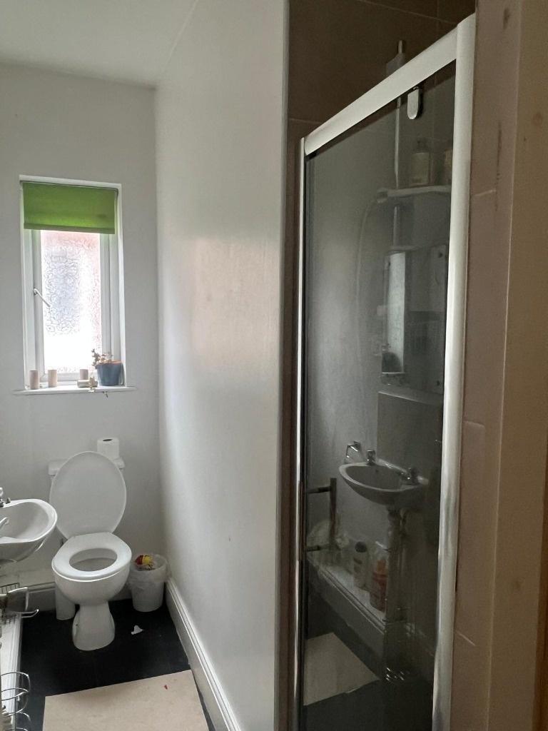 Compact bathroom with shower cubicle and window...