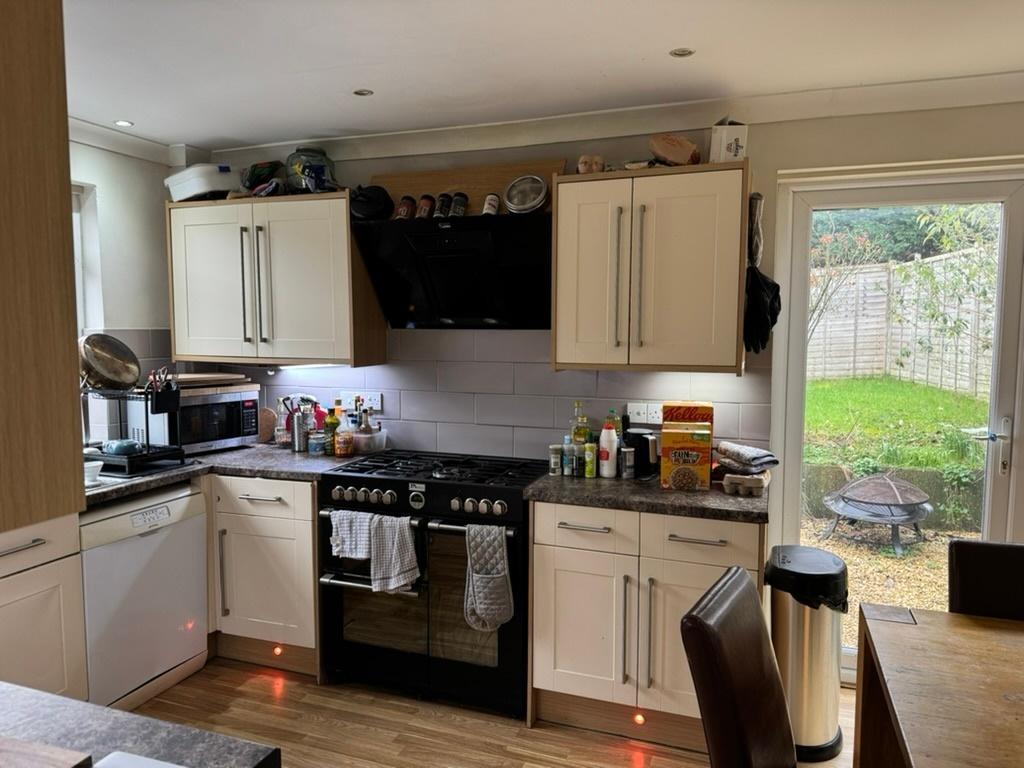 Bright, modern fitted kitchen with cream cabine...
