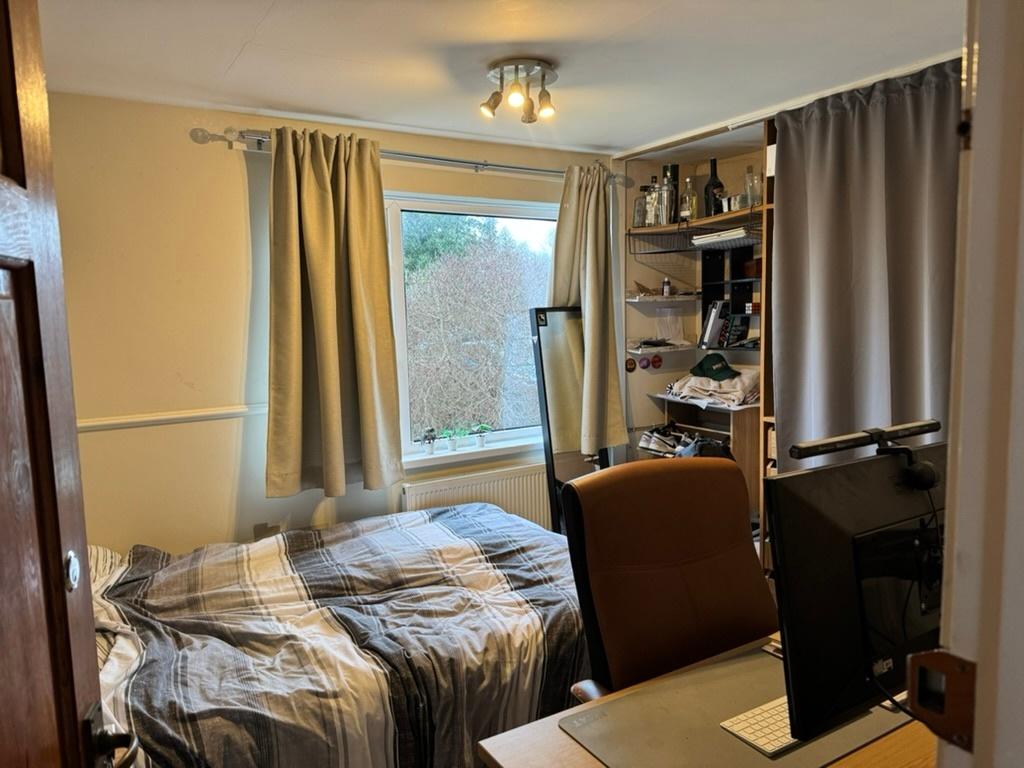 Cozy double bedroom with a large window providi...