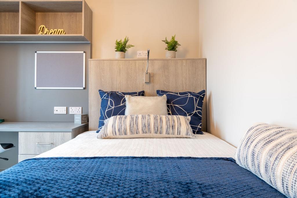 Bright, neatly styled bedroom with a comfortabl...
