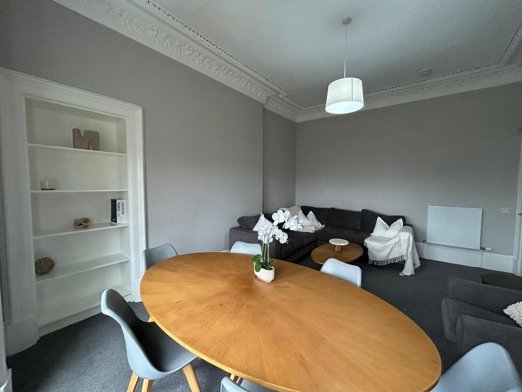 Bright sitting room with dining table and sofa...