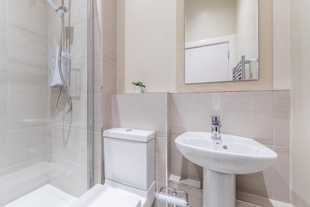 Bright modern bathroom with shower and pedestal...