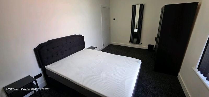 A well-maintained bedroom featuring a spacious ...