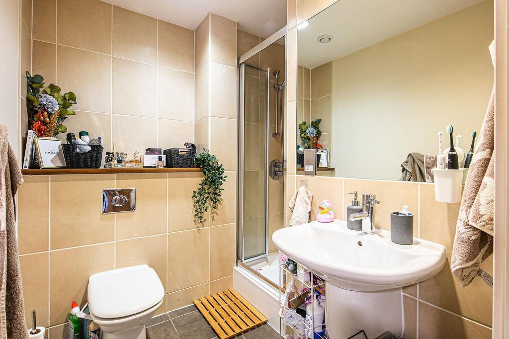 Well-presented tiled bathroom with a shower cub...