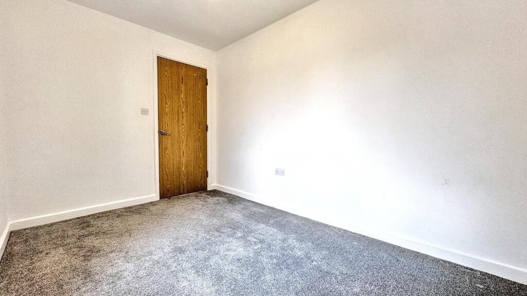 Bright, neutral bedroom with carpet and woodend...