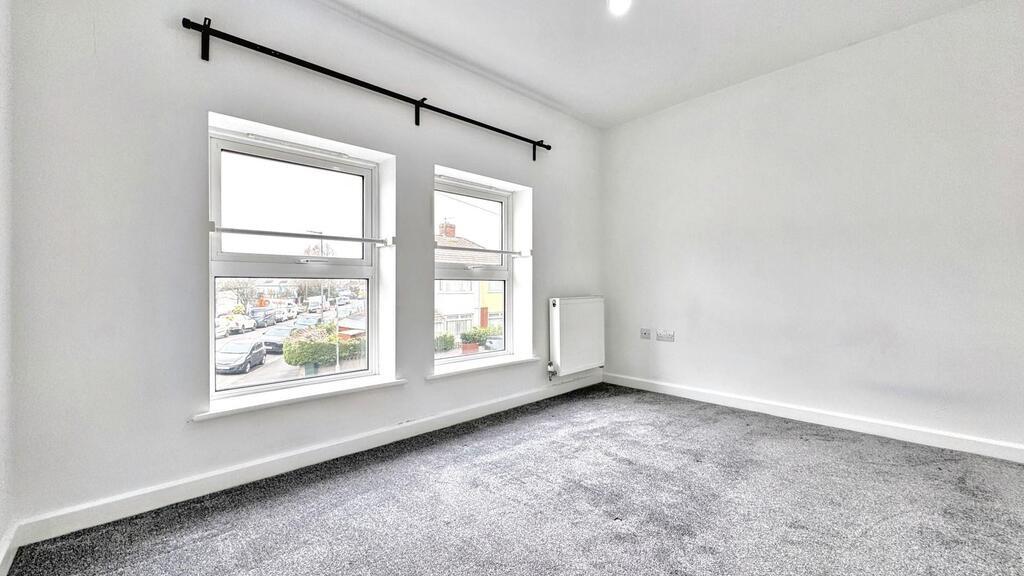 Bright bedroom with large windows and neutral f...
