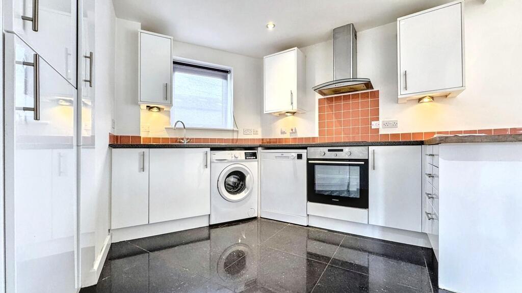 Bright modern kitchen with integrated appliance...