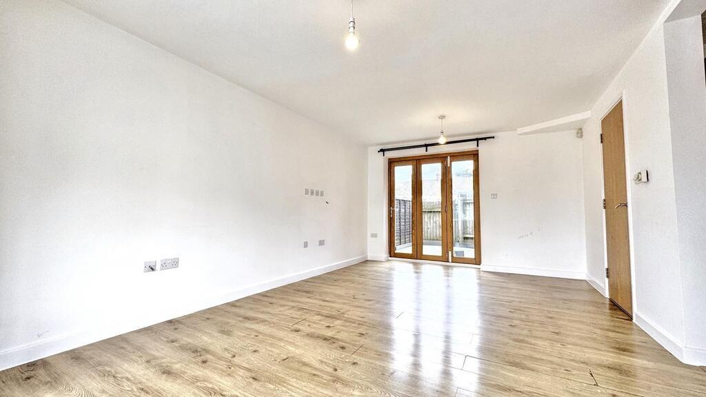 Bright open-plan living area with wood floors...