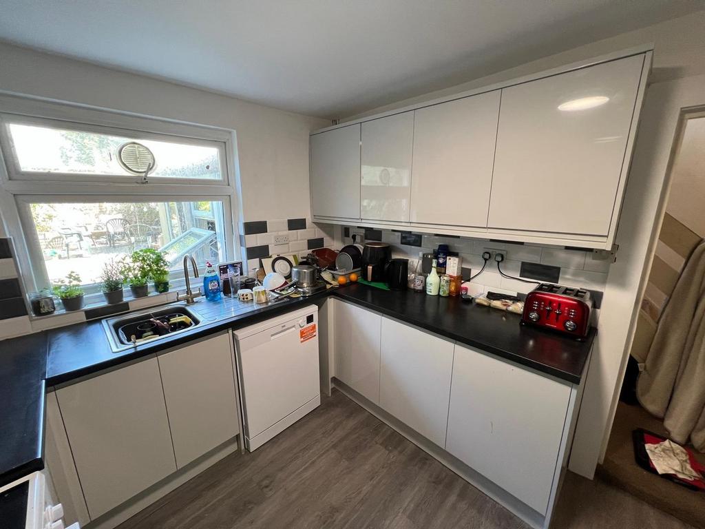 Bright modern kitchen with sleek white cabinetr...