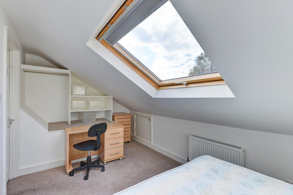 Bright attic bedroom with a large skylight, fit...