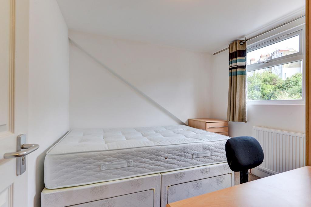 Bright, simply furnished bedroom with a double ...