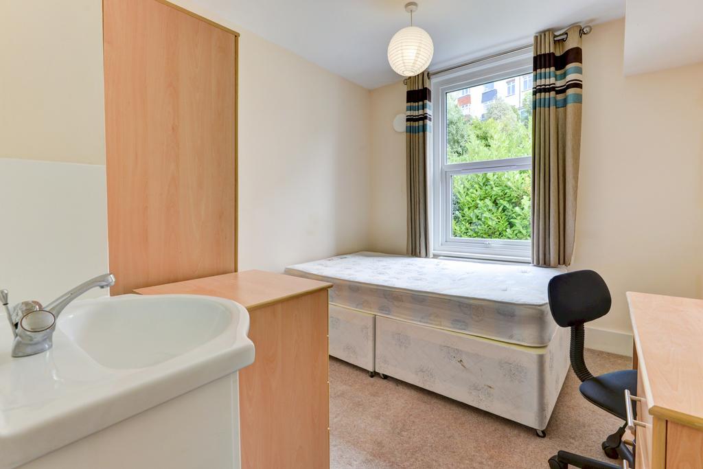 Bright single bedroom with a raised bed and und...