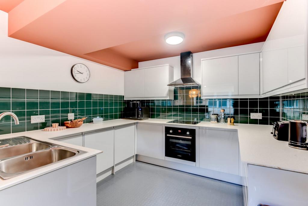 Bright modern kitchen with white gloss cabinets...