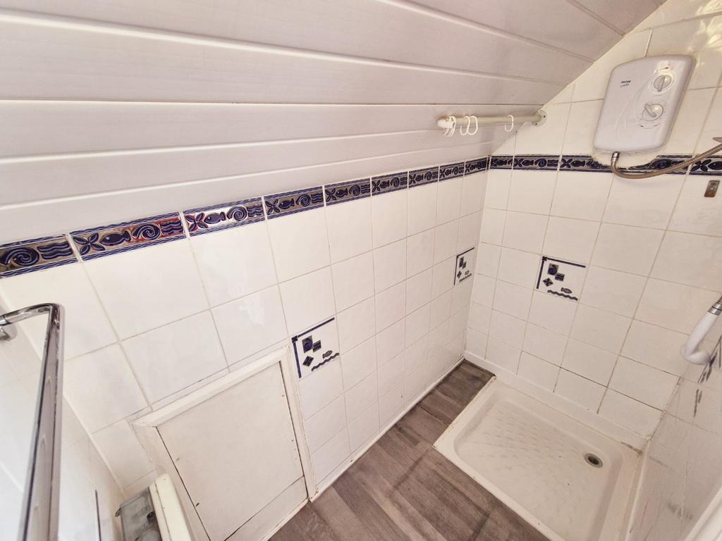 Compact tiled shower area with fitted shower tr...