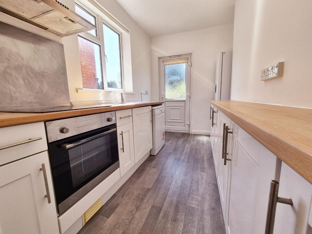 Bright modern galley kitchen with wooden workto...
