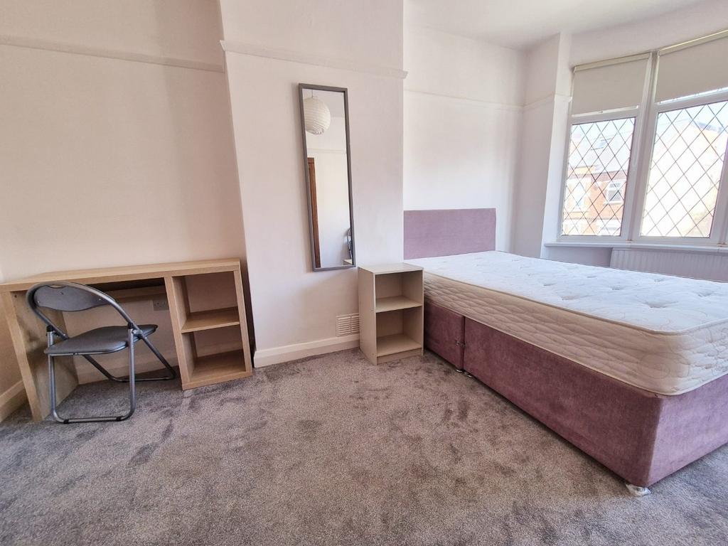 Bright bedroom with bed, desk and storage...