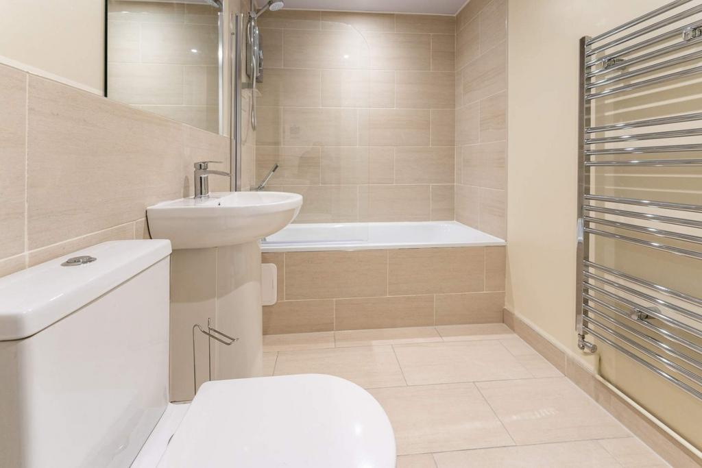 Modern tiled bathroom with bath and heated rail...