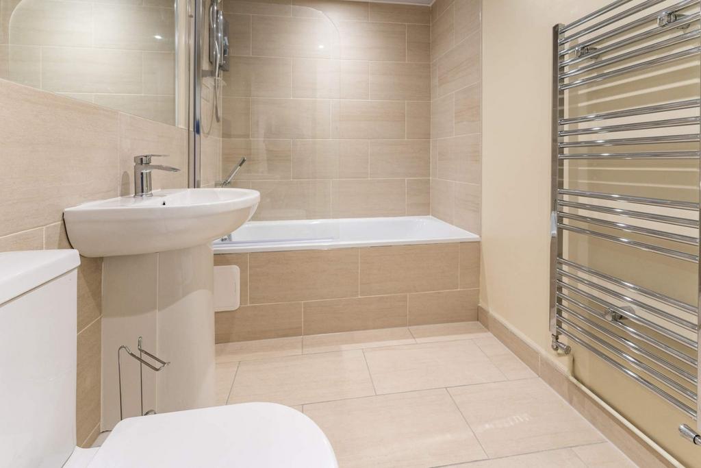 Modern tiled bathroom with bath and heated rail...