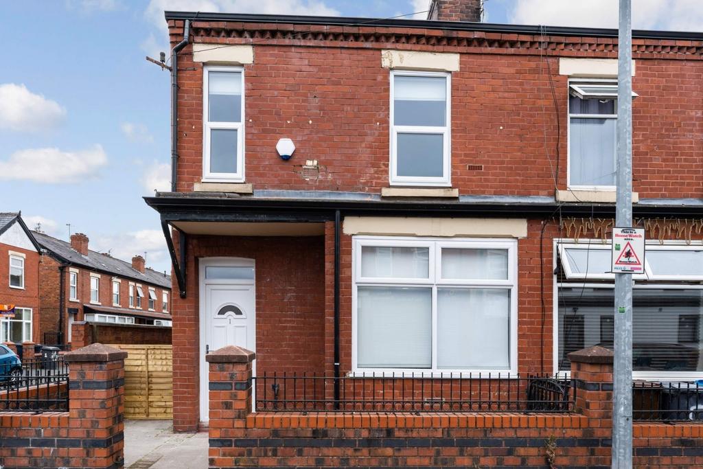 Red-brick end terrace with bay window and gated...