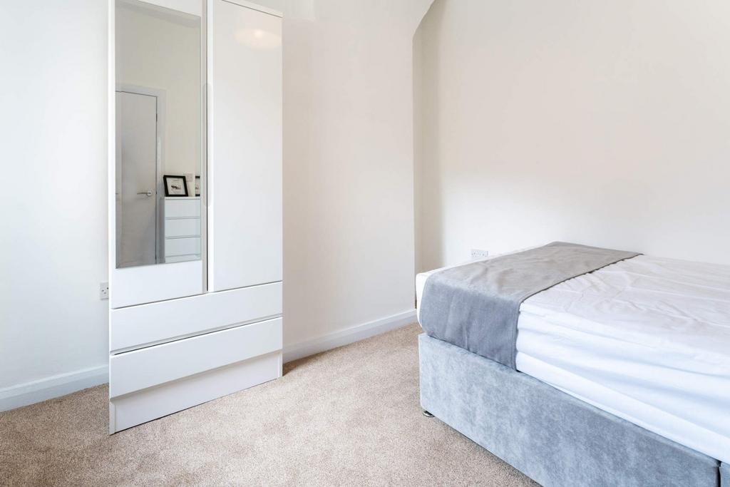 Bright, neat room with bed and mirrored wardrob...