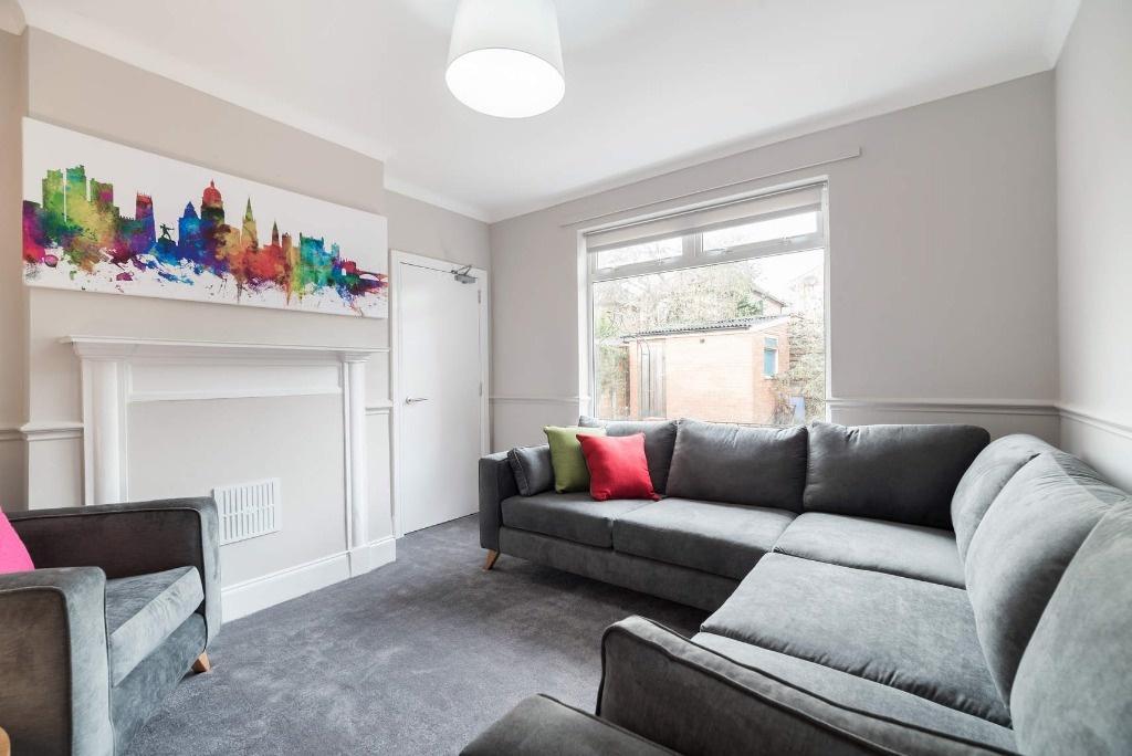 Bright, modern lounge with large sofa and mante...