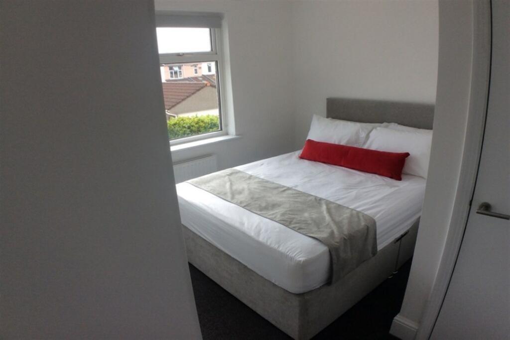 Bright, neatly made bedroom with comfy double b...