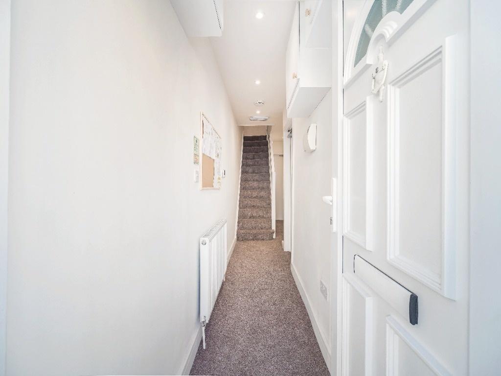 Bright, clean entrance hallway with stairs ahea...