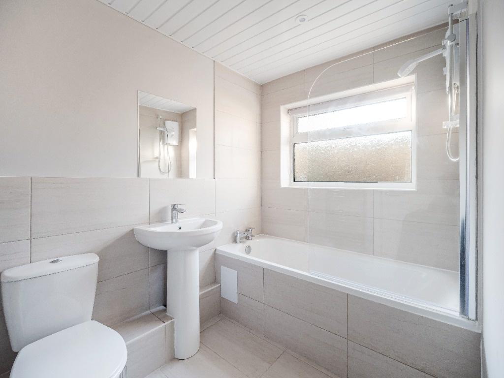 Bright, modern bathroom with bath and window...