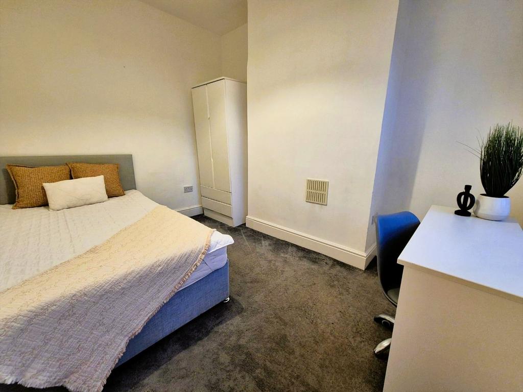 Neat, bright bedroom with desk and storage...