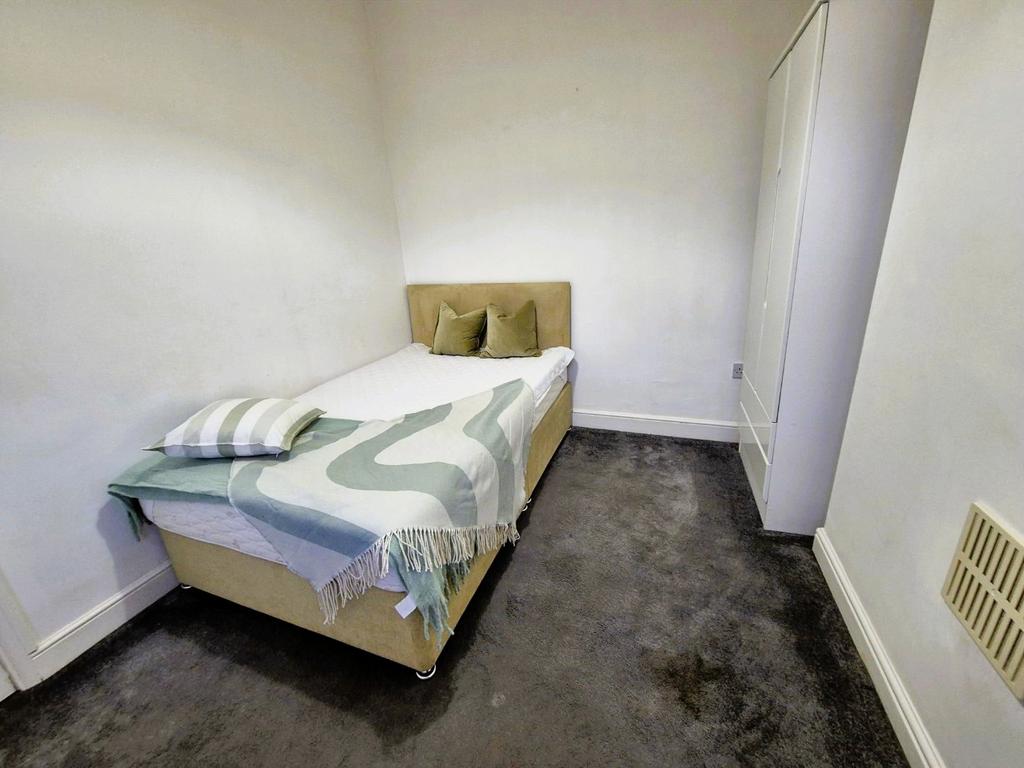 Compact furnished bedroom with double bed and w...