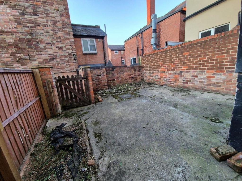 Private paved yard with brick walls and gate...