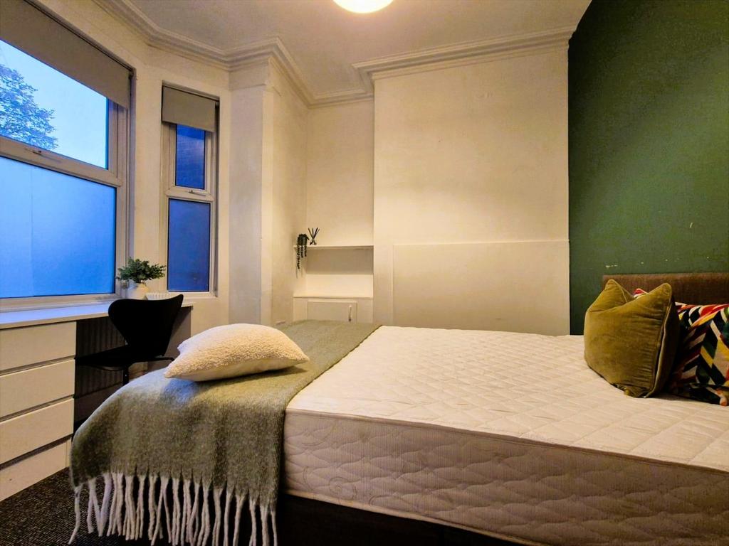 Bright, tidy bedroom with bed and desk...