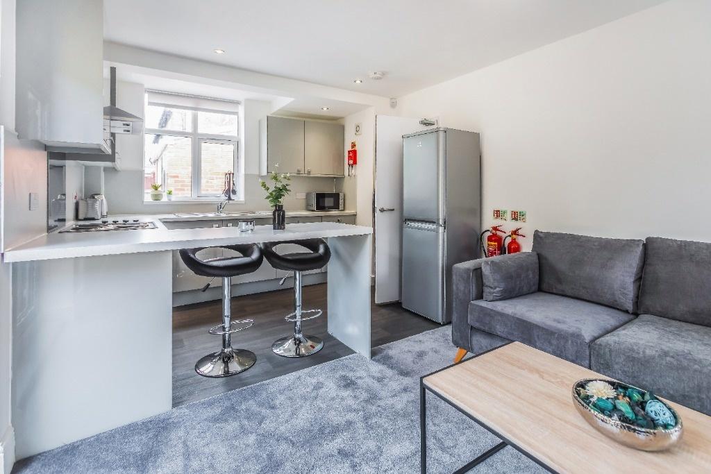 Bright open-plan living area with kitchen bar...