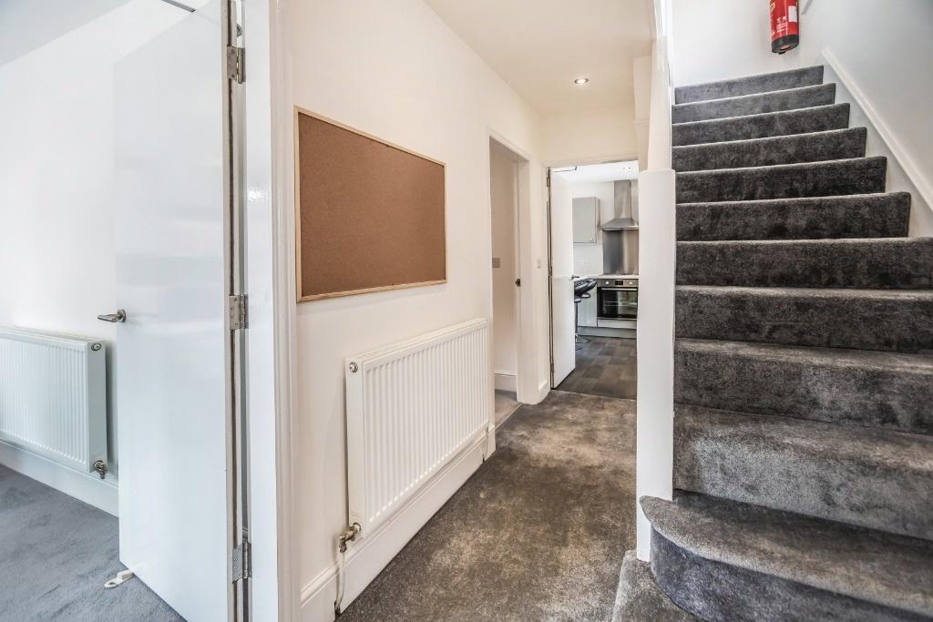 Bright, modern hallway with staircase and notic...