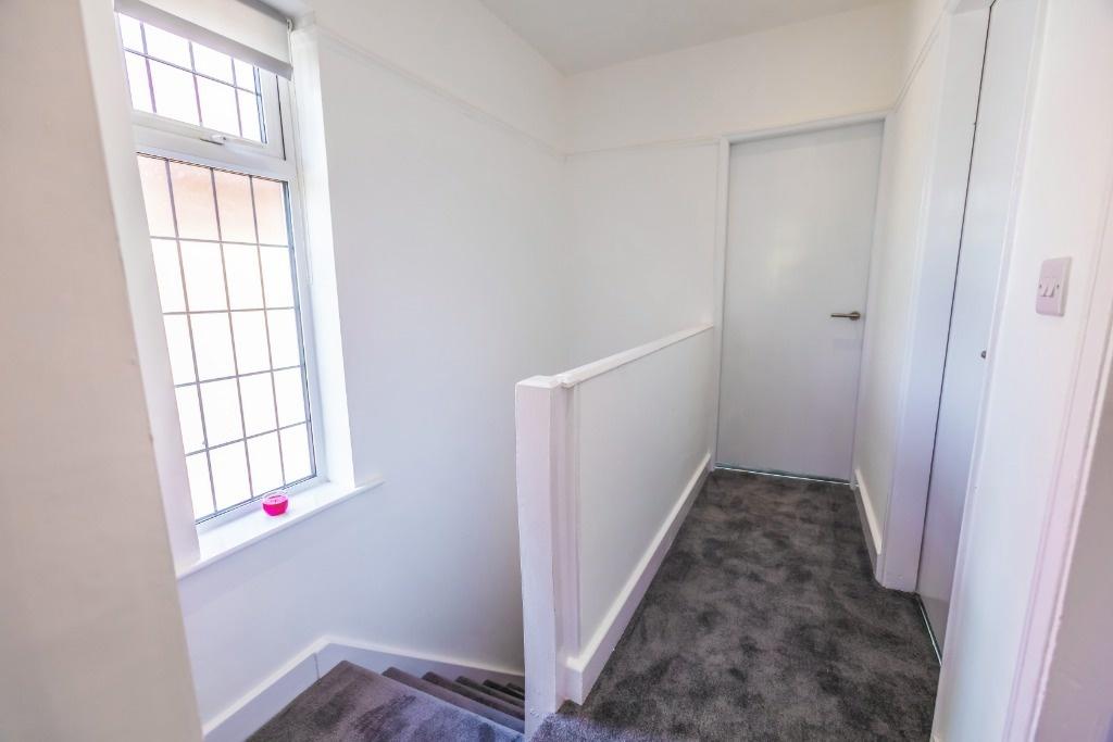 Bright landing with window and neutral carpet...