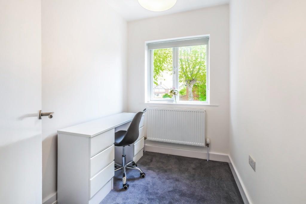 Compact bedroom with desk and window...