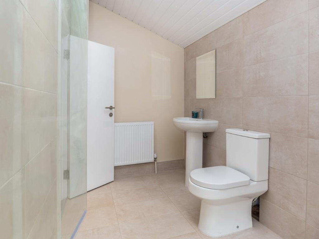Bright modern bathroom with shower and clean ti...