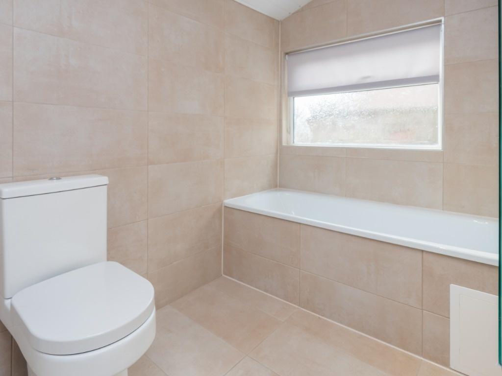 Bright modern bathroom with tiled bath and WC...
