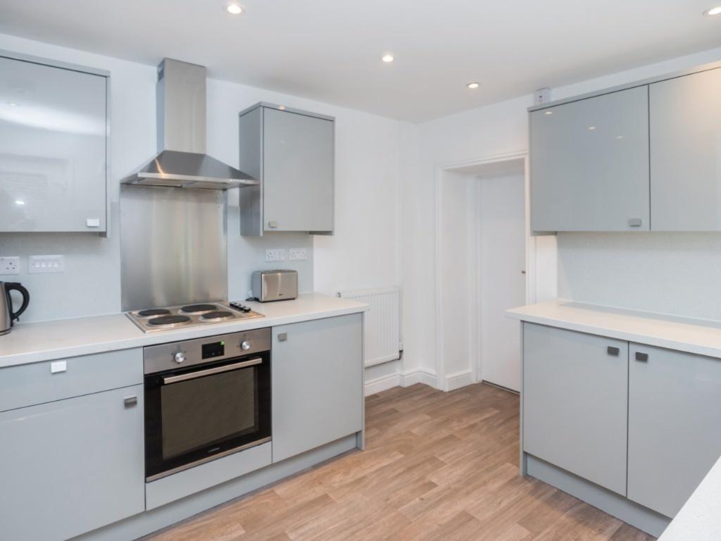 Modern fitted kitchen with integrated oven and ...