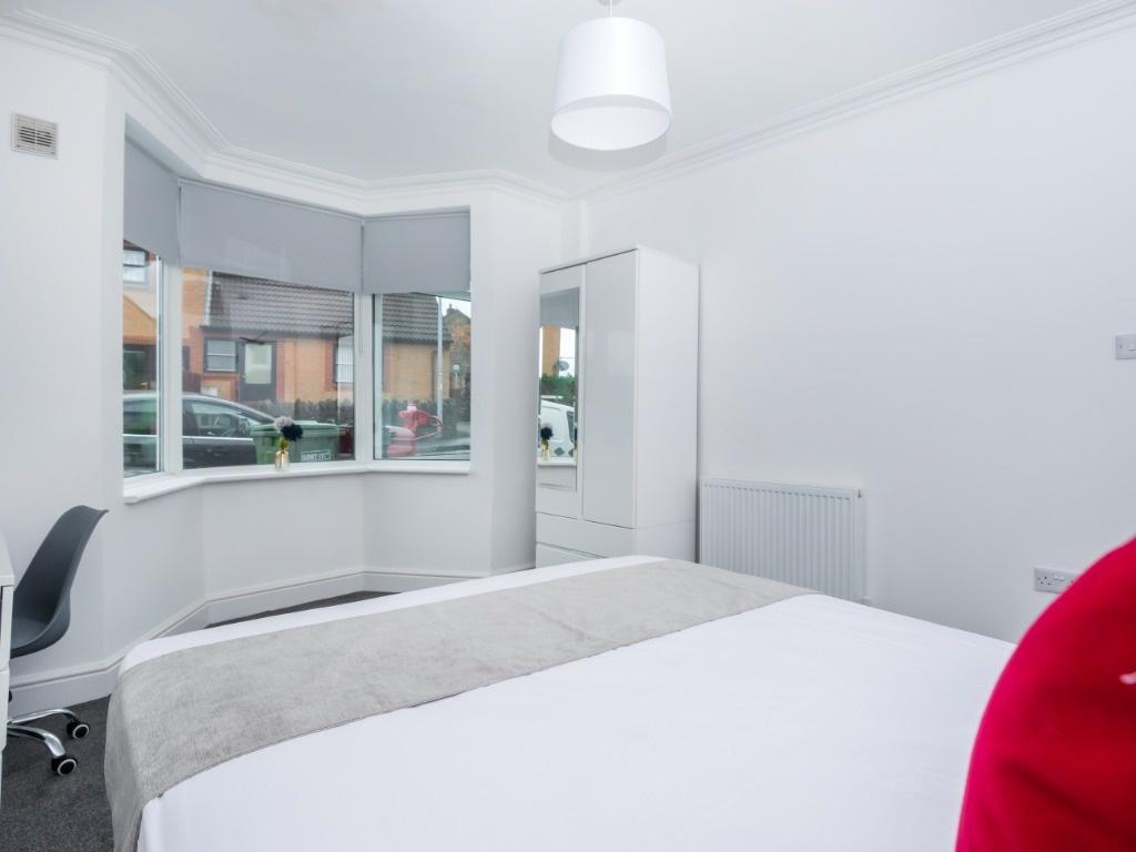 Bright bedroom with bay window and neutral déco...