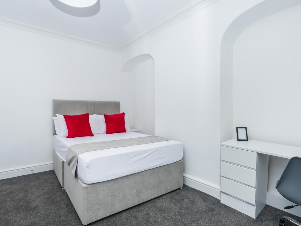 Bright double room with modern bed and desk...